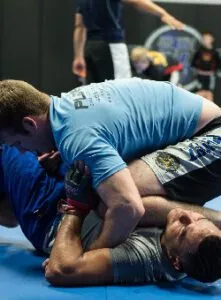 Close-up of two males with short hair wearing 10th Planet Beaumont gear training Brazilian jiu-jitsu.